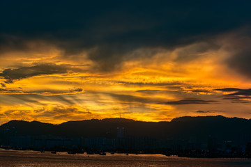 Incredible sunset over sea with a silhouettes of a cargo vessels.