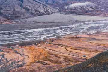 View over beautiful Adventdalen fjord from above, Riverbed bedween mountains, lonley house in the arctic tundra of Svalbard or Spitsbergen, northern Norway
