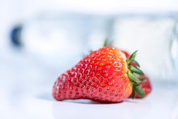 Strawberries in front of a water bottle, tasty and organic fruit, isolated, close up