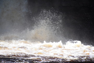 waves at the bottom of a waterfall
