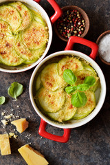 Zucchini casserole with cheese and bechamel sauce. View from above. Kitchen table with dishes.