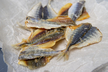 Salted fish lies in unfolded paper.