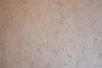 Abstract background. Oriental chipboard is painted with white paint. Visible glued wood chips.