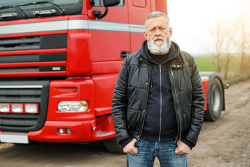Portrait of mature driver at modern truck outdoors