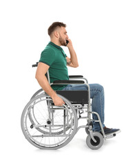 Young man in wheelchair talking by mobile phone isolated on white