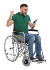 Happy young man in wheelchair with mobile phone isolated on white