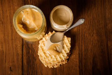 top view on belgian waffles, and glass jars with honey and tahini