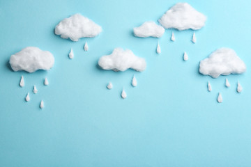 Clouds and raindrops made of cotton on blue background, flat lay. Space for text