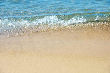 Fototapeta na wymiar View of sea water and beach sand on sunny day