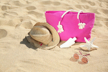 Stylish beach accessories on sand near sea