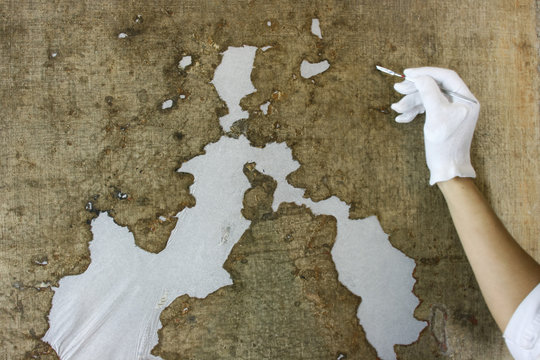 restoration and conservation of a very old canvas, restoration of a painting, restorer at work, place for text