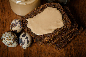 top view closeup rye bread slices with tahini butter and quail eggs