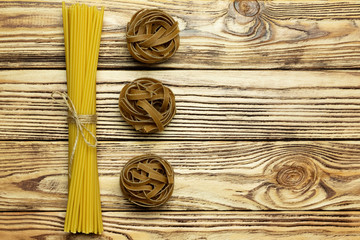 Collection of italian pasta top view on vintage wooden background.