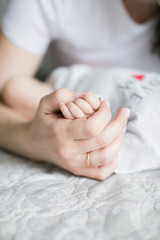 New life. Newborn child. Children and pregnancy. Baby and parents. Little pen in the hands of mom and dad. Happiness, the continuation of the human race.