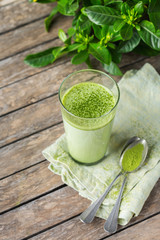 Glass of matcha green tea latte on a wooden table
