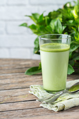 Glass of matcha green tea latte on a wooden table