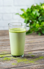 Glass of matcha green tea latte on a wooden table