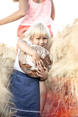 Kind mit Brot im Feld Weizenfeld Ernte Sommer Ernährung Getreide Kindheit 