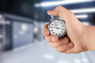 Metal stopwatch in Human Hand on office background