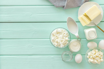 Eggs, butter, milk, yougurt, cottage for natural farm products yougurt mint green wooden background top view copyspace
