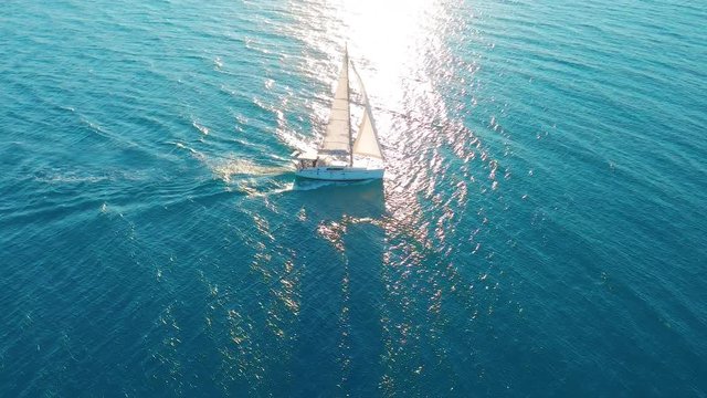 Aerial view. Yacht sailing on open sea at sunny day. Sailing boat in sea.