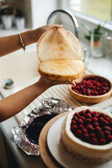 Girl baker prepares a delicious berries cheesecake