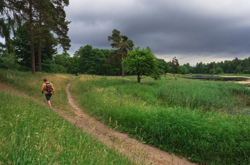 A man in inclement weather is on the path of the Park