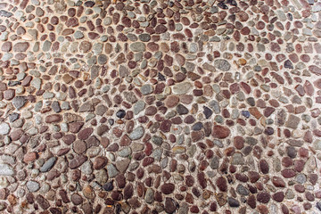 Round stone paving. Natural stone masonry top view. Seaside pebble photo texture.
