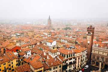 Fototapeta na wymiar View on the old town Verona in aerial view, Italy. Fog above in Verona. red roofs of a medieval city in Italy