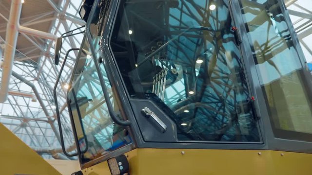 Glass cabin with multiple control levers in a construction grader. A new sample is presented for review at the exhibition. Shot in motion
