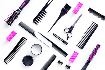 Combs, sciccors and pink hairdresser tools in beauty salon work desk on white background top view pattern