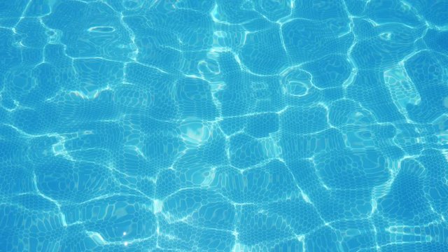 Turquoise water playing cheerily in a swimming pool on a sunny day in slo-mo  