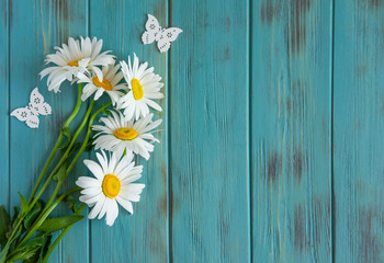 Frame for text with daisies. Daisies on a light wooden background. Design basis for greeting card....