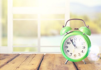 Retro alarm clock on flowers background