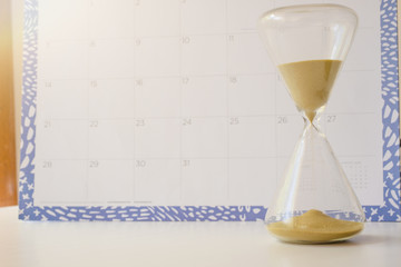 Hourglass and calendar in the background, concept of passing time, wet date or event