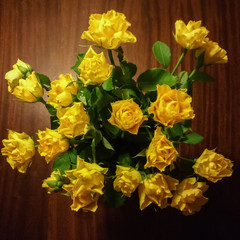 Bouquet of yellow roses on a wooden table