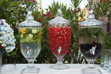 Fresh fruit and vegetable drink in a glass pitcher with tap, close-up