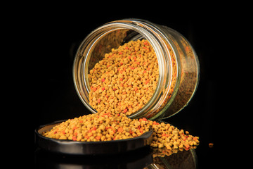 macro raw bee pollen grain poured out from glass jar