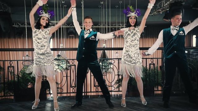 Theme party - Young people in glistening retro clothes dancing on the floor