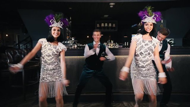 Theme party - Young people in glistening retro clothes dancing using swing elements