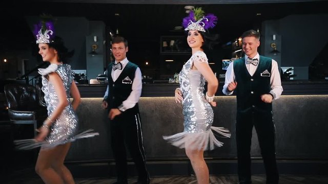 Theme party - Young smiling people in glistening retro clothes dancing