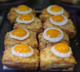 Baby fried quail eggs on top of a pastry. 