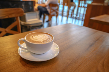  Latte art coffee on wooden table in coffee shop