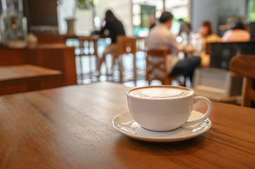 White cup of coffee on table interior coffee shop.