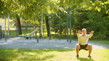 An athletic man warming up his legs with basic squatting