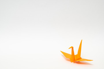 orange origami paper crane on white background