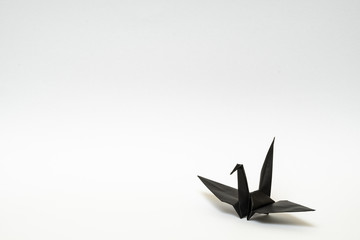 black origami paper crane on white background