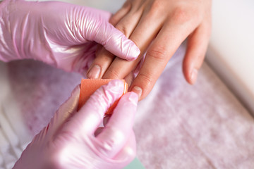 Male manicure. Professional master in gloves makes a manicure on male hands with the help of a...