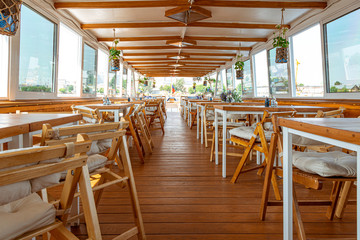 The interior of the urban river ship, with a panoramic view of the urban landscape. The concept of tourism, recreation, walking around the city, rest in the city. River transport.