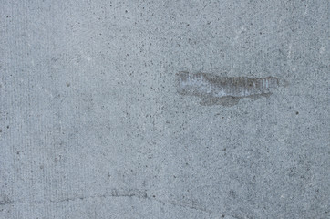 Wall of gray cement with adhesive residue.